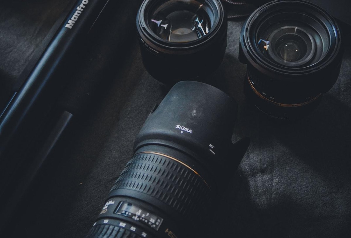 camera lenses body and tripod laying on table